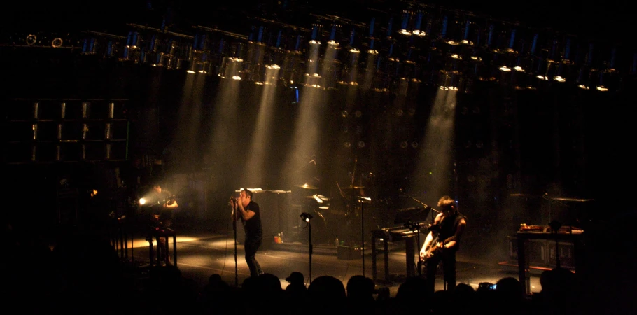 two male and a female musicians performing on stage