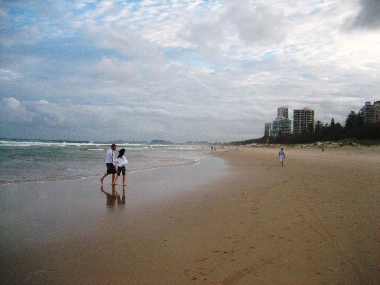 a couple is standing on a beach with their arms around each other