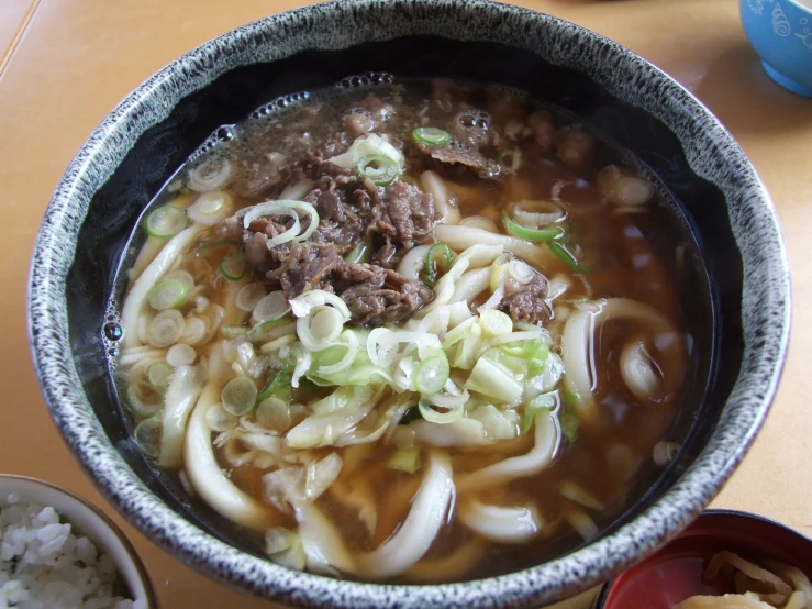 a bowl filled with pasta and meats in a broth