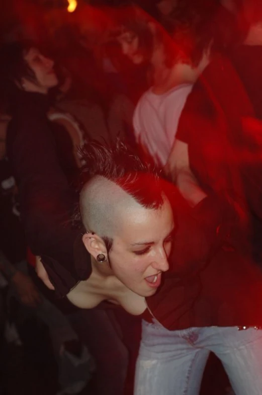 a woman smiling as she dances in the dark