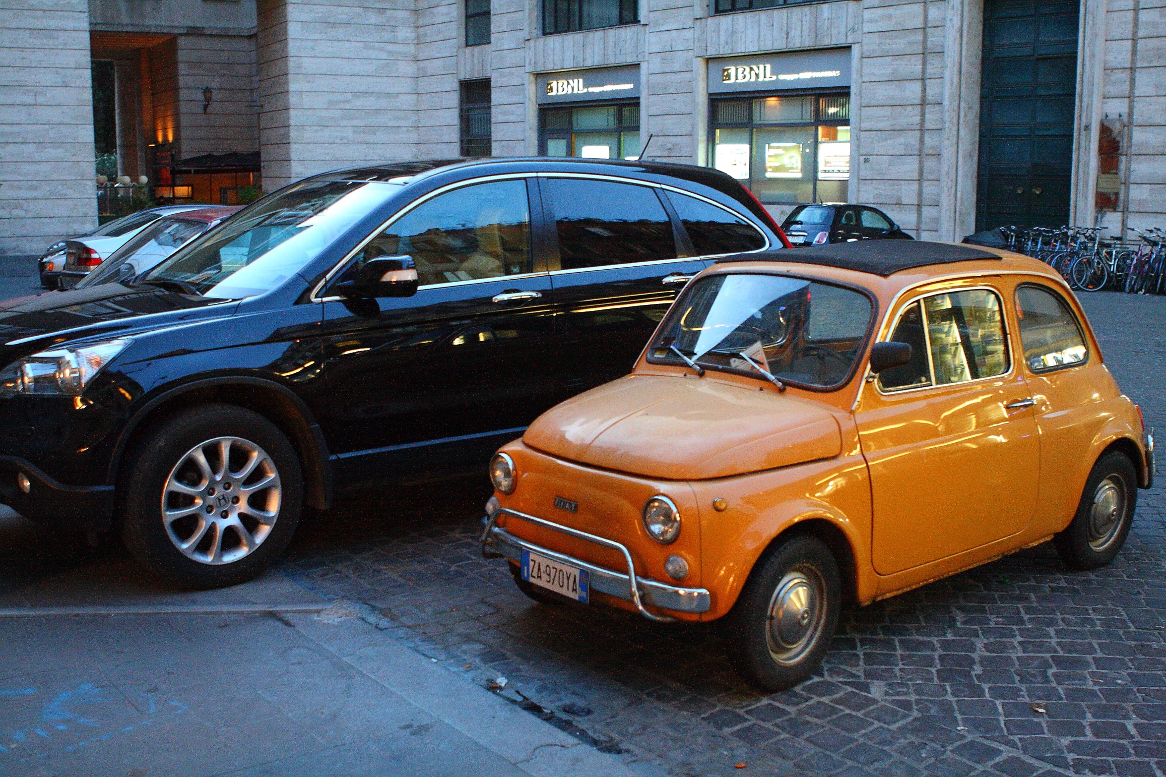 two old and new cars parked on the street