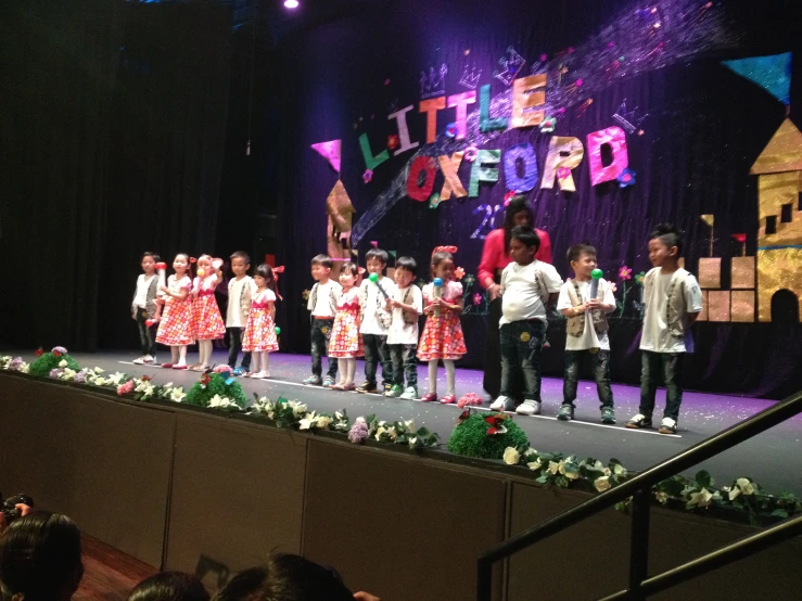 children on stage during a performance for a school