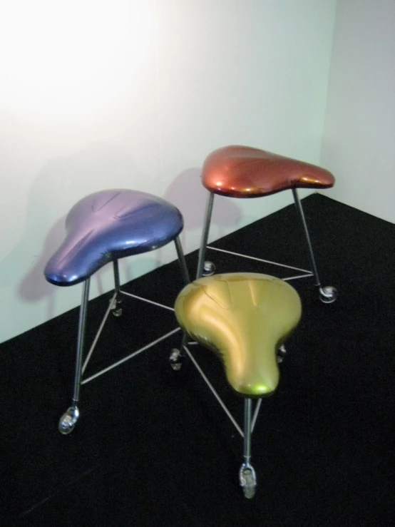 three chairs with chrome legs in a small room
