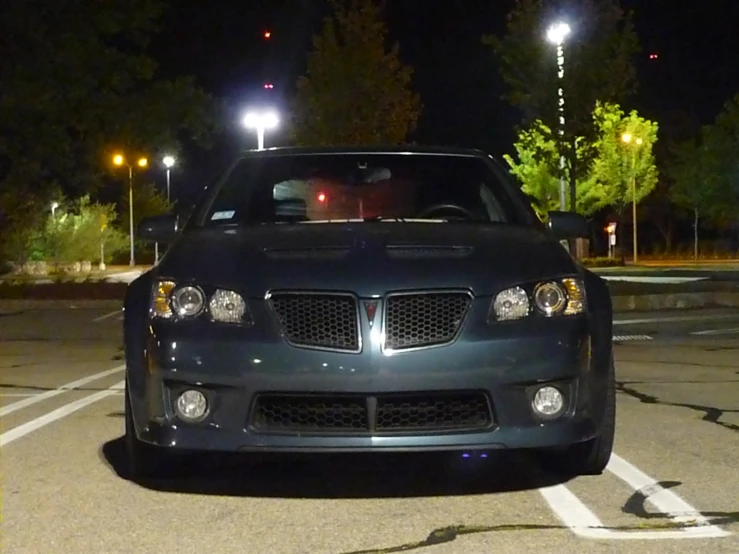 a car is parked in the parking lot with another car at night