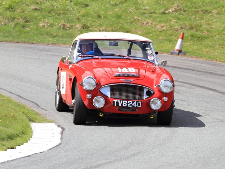 an old fashion red car racing down the street