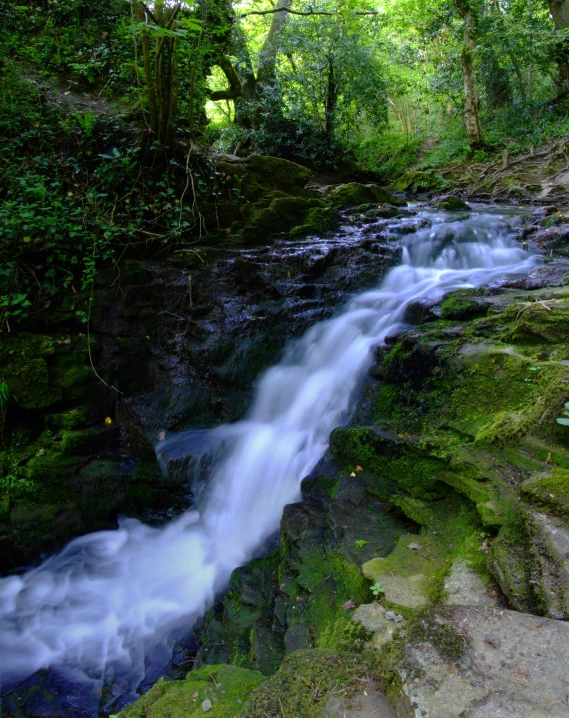 the waterfall runs down a rocky cliff