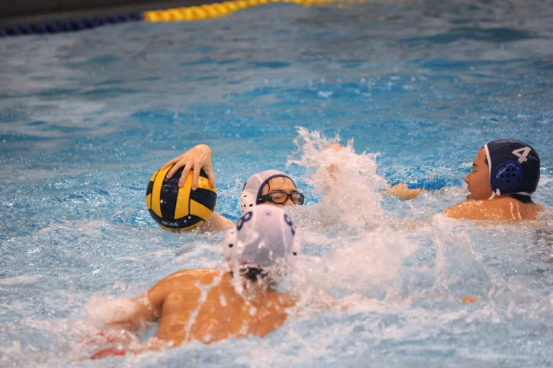 two women are playing ball in a pool