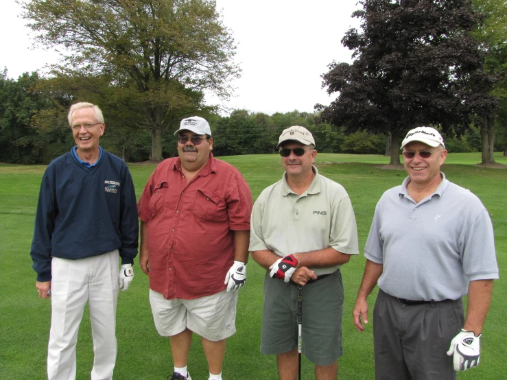 four men pose for the camera in golf gear