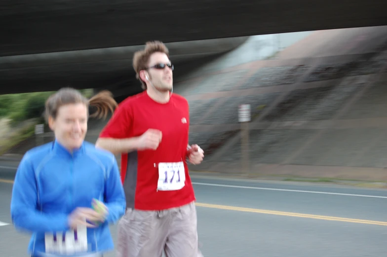 a man and a woman are running down the street