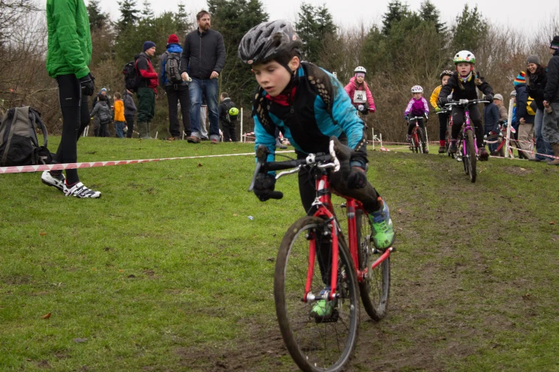 a person on a bike in the grass with other people