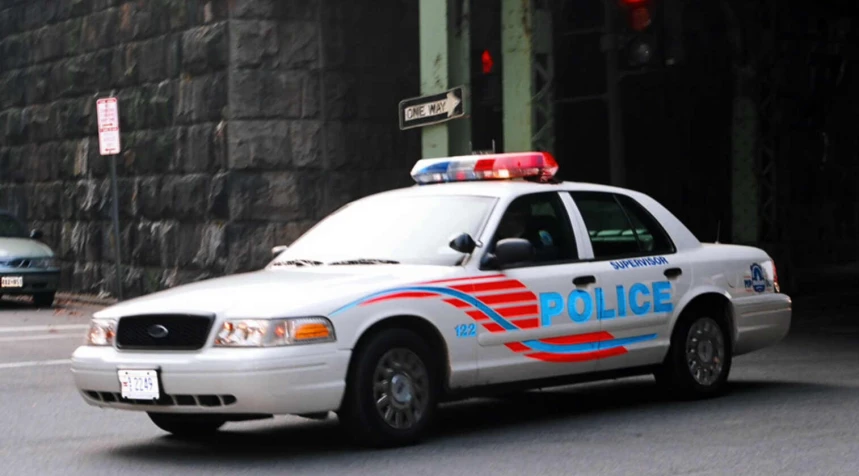 a police car driving through the city on a street