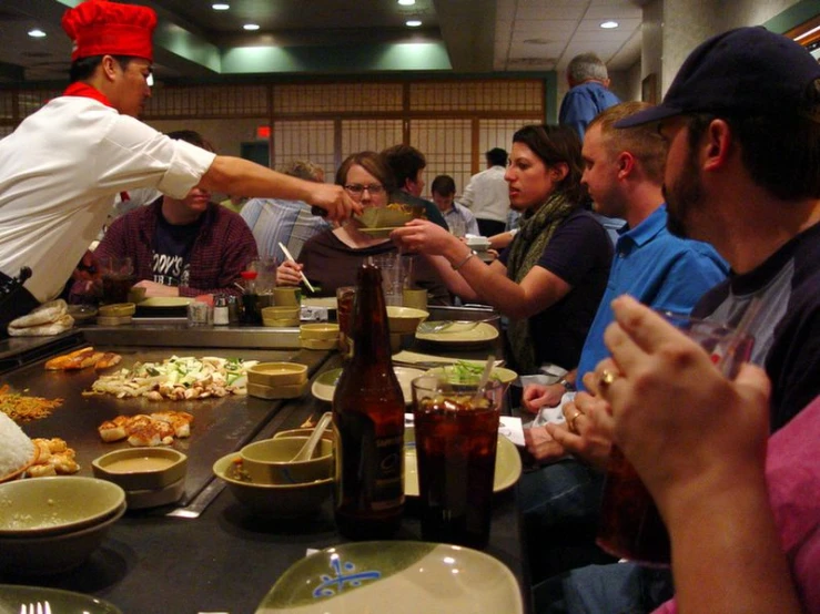 a chef is serving food to a large crowd