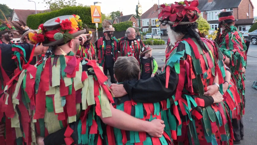 a group of people dressed in red, green and yellow standing on the street