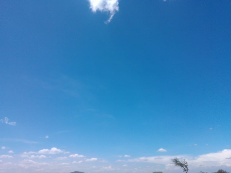 a man flying a kite in a blue sky