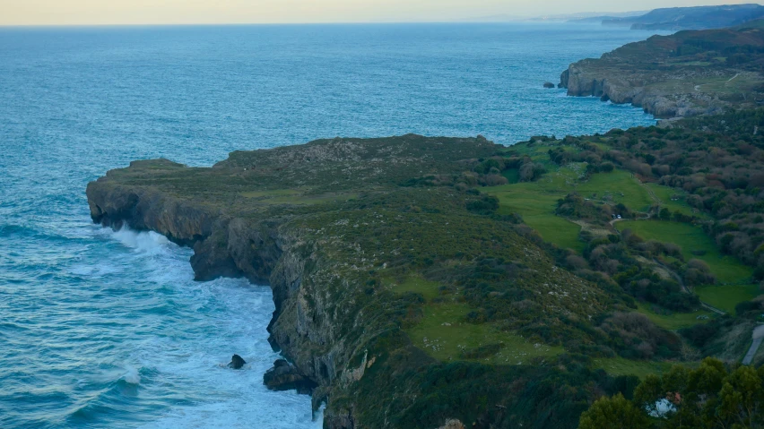 the island has a cliff on top of it next to the water