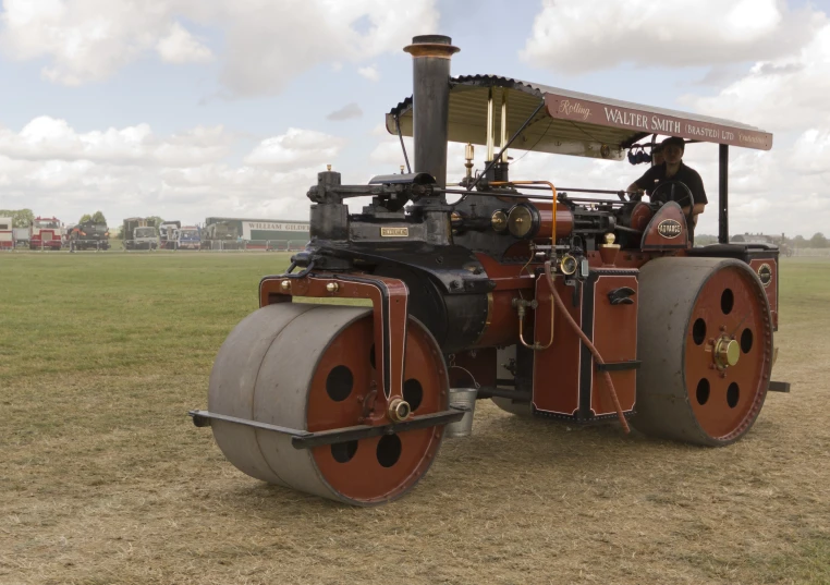 an antique tractor has a man in it