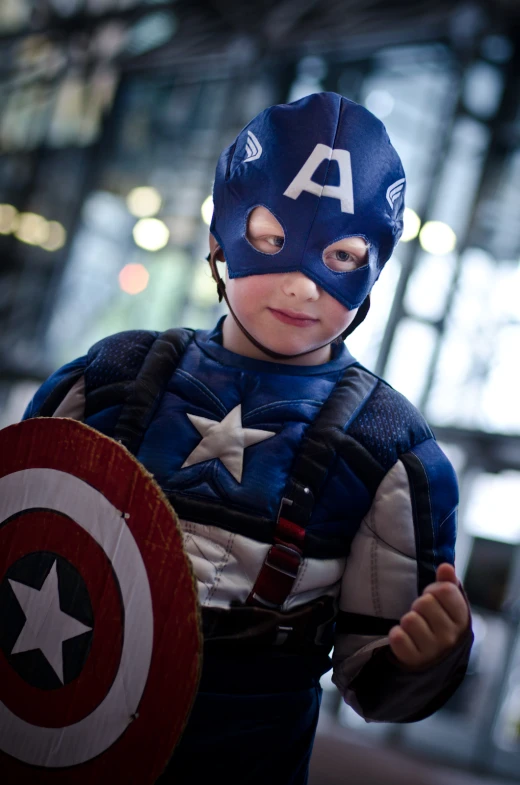 a child in a costume with the shield of captain america on it