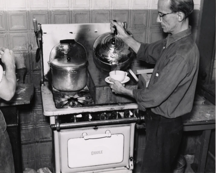 two people standing next to each other looking at a stove