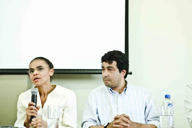 two people are sitting at a conference talking