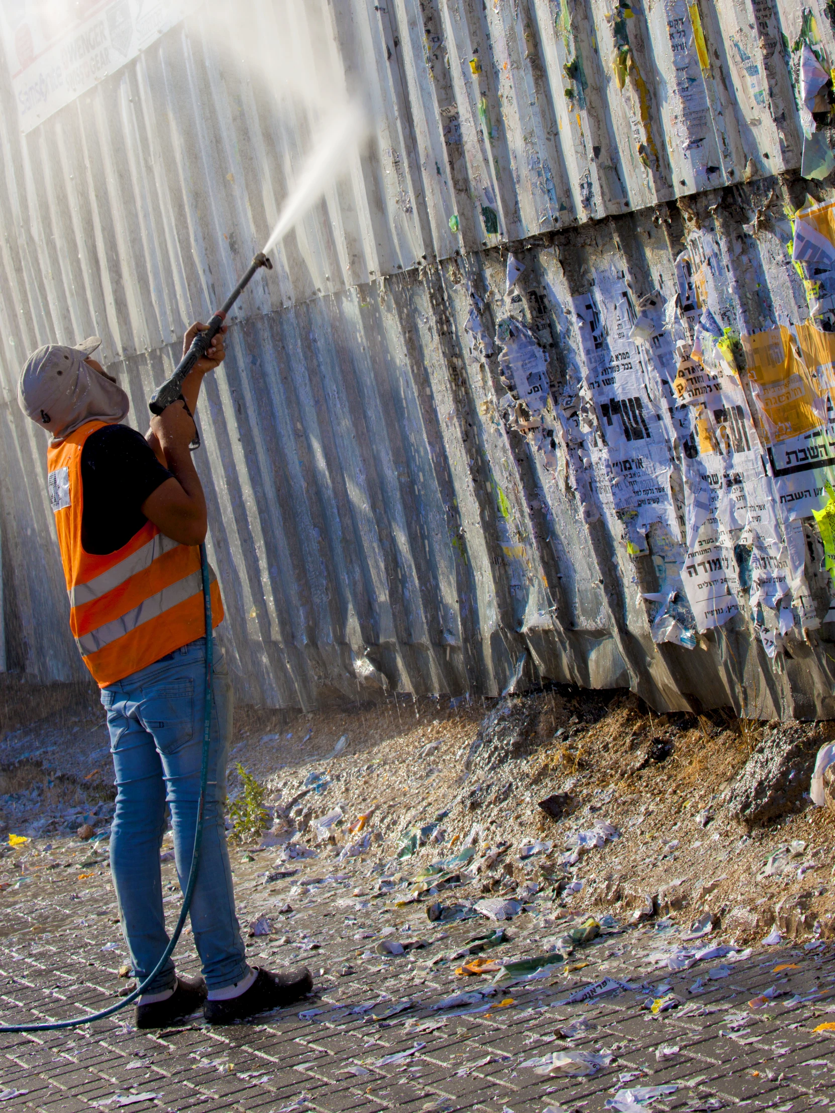 a man with an orange vest is spraying graffiti on a wall