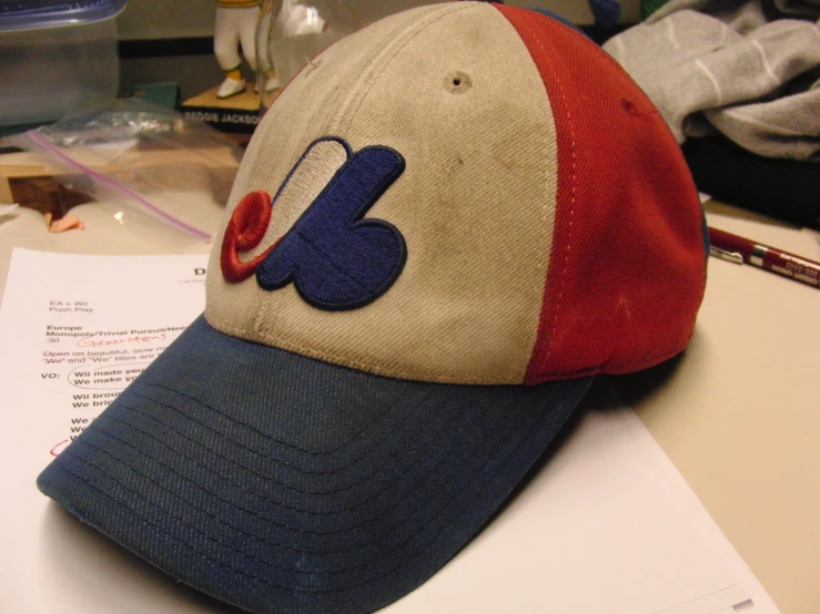 a baseball cap on a table with a pen