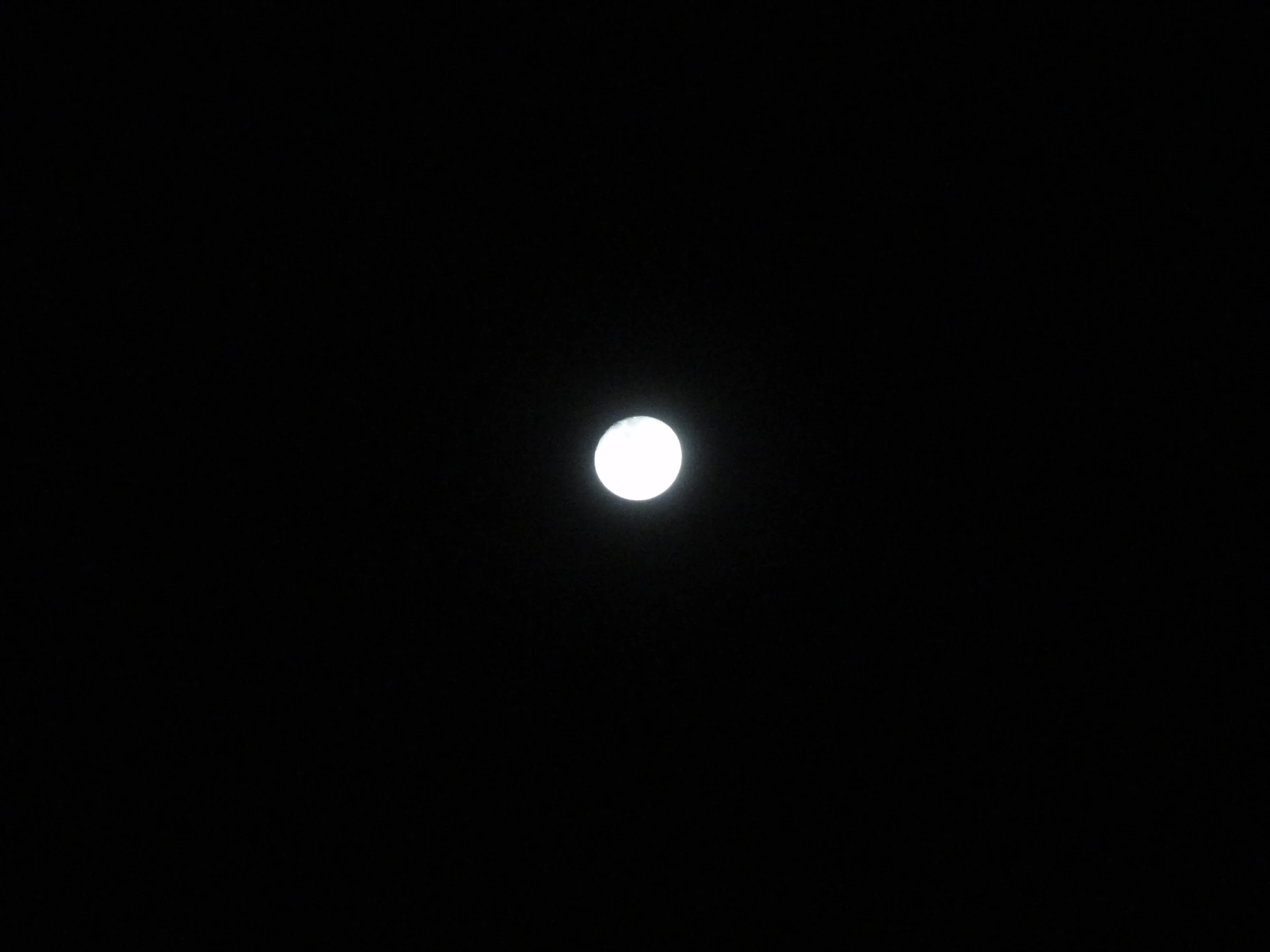 the moon is in the dark sky with a small light