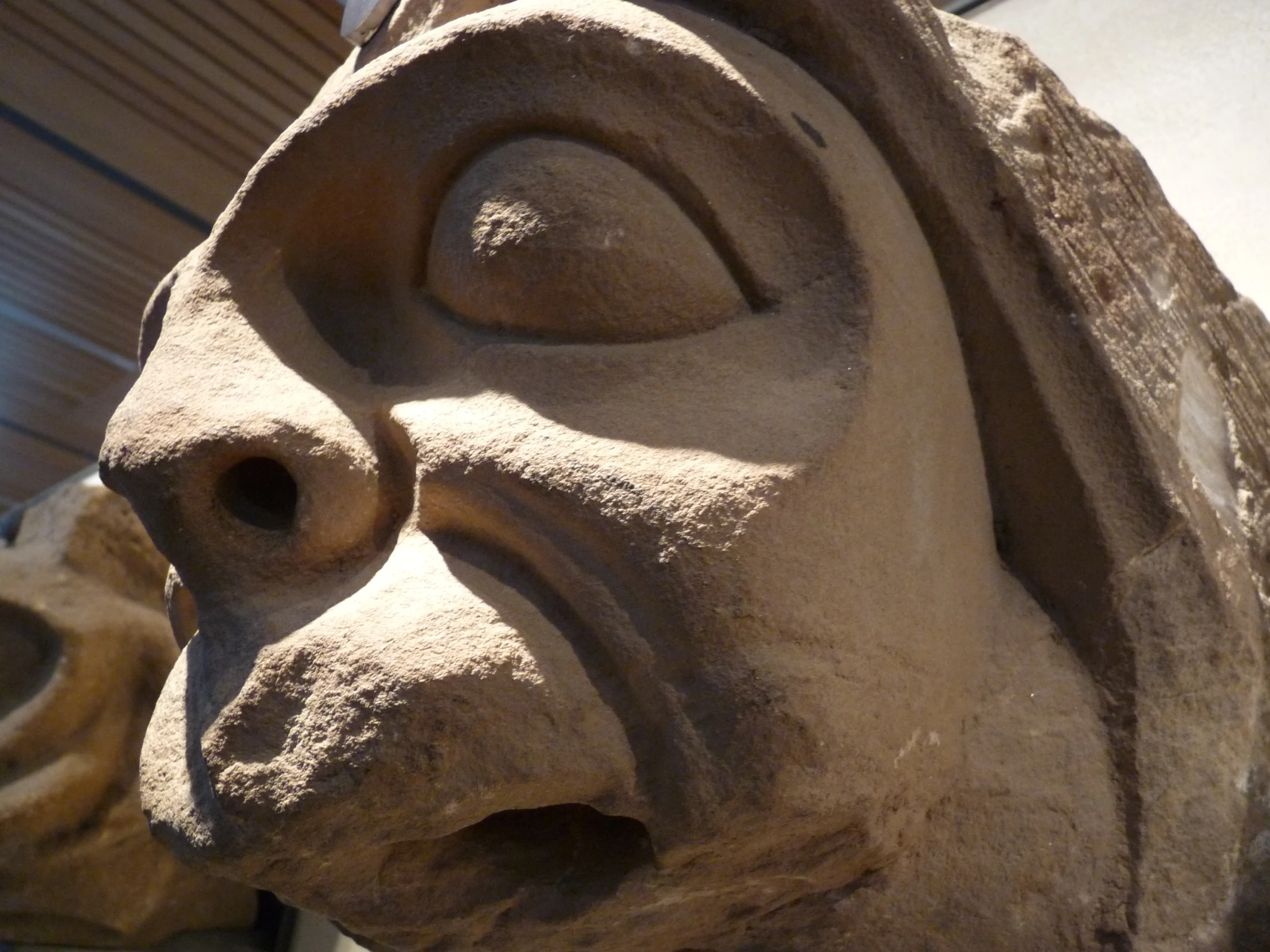 a stone face statue near the corner of a building