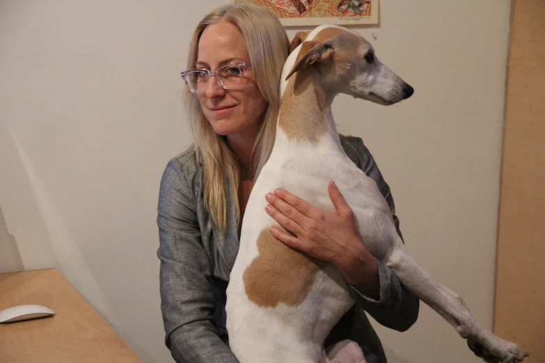 a woman hugging a dog on the lap