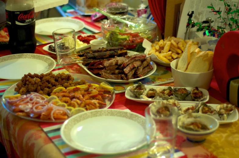 the table is full of many different plates of food