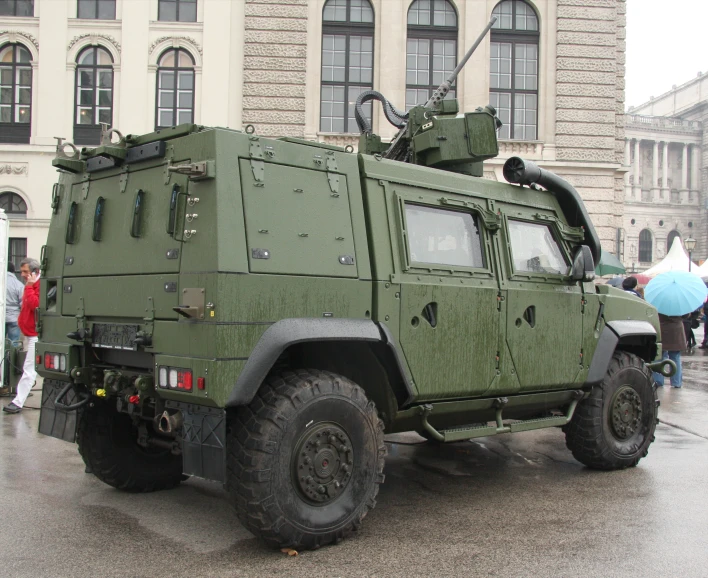 green army vehicle with people standing near it