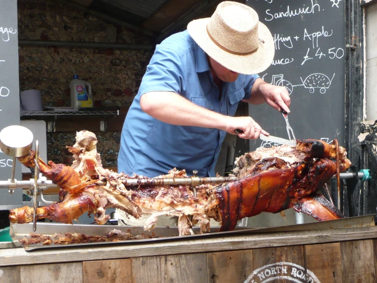 the man is preparing several cooked animals on a cart