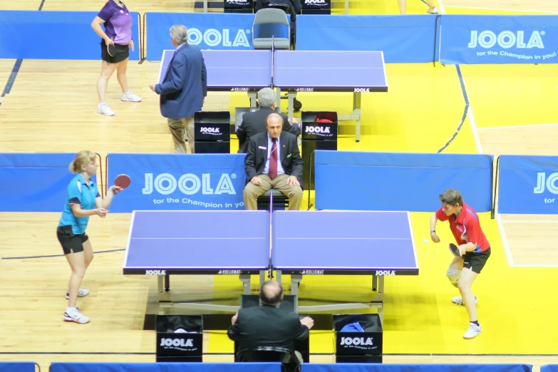 table tennis players are practicing on a court