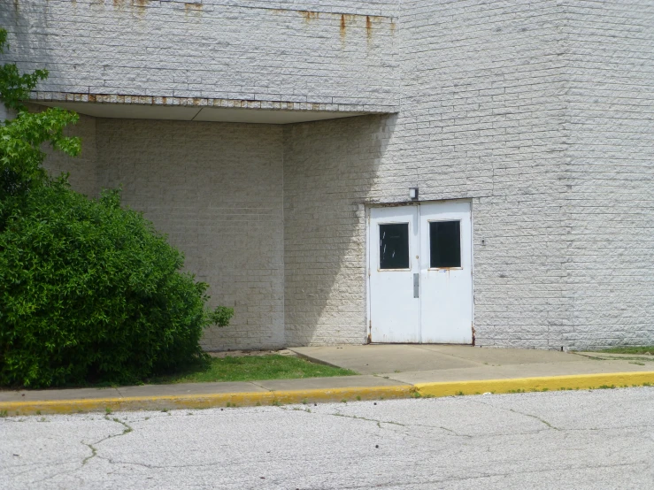 a doorway in a building with a small bush by it