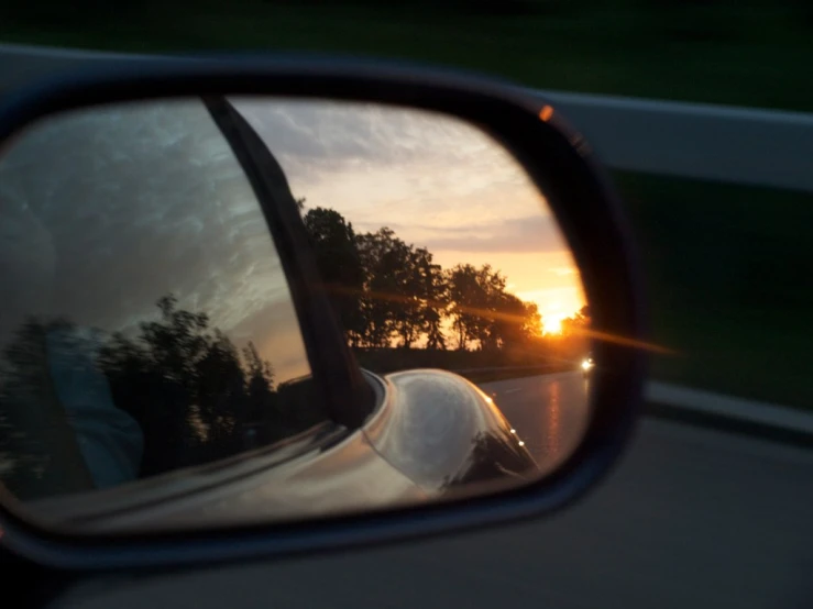 a reflection in the side view mirror on a car