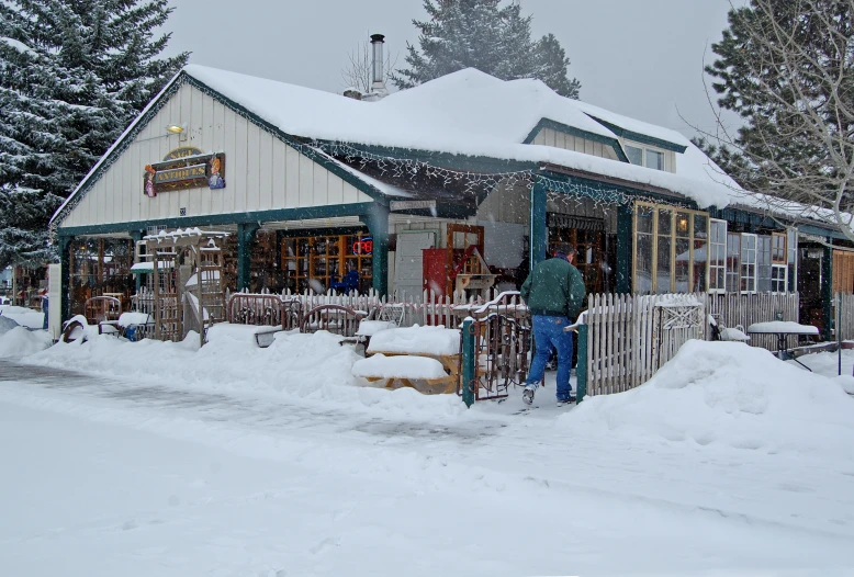 a person standing outside a shop on a snowy day