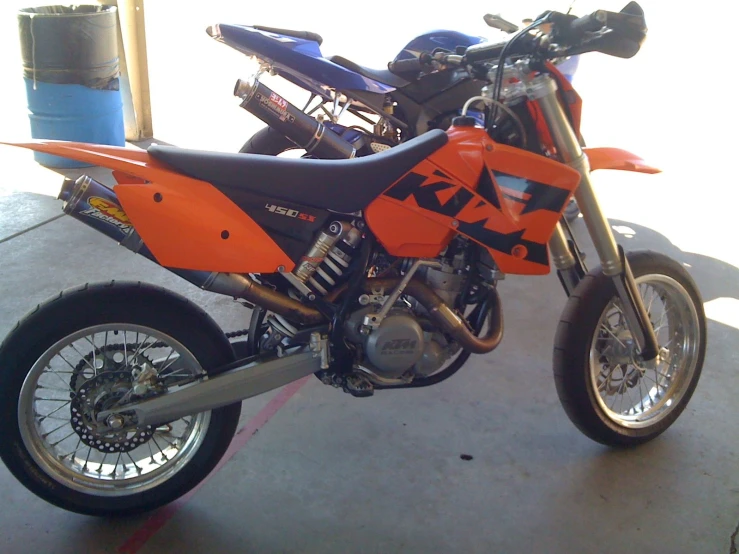 a dirt bike is parked on the pavement near a pole