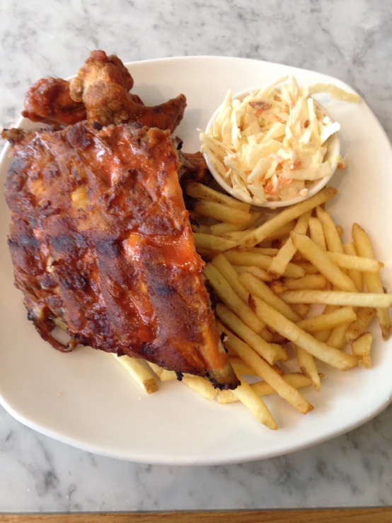 a white plate topped with meat and french fries