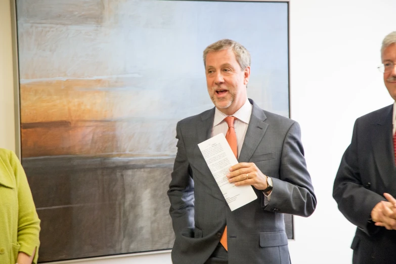 some people in suits and ties and two women are in front of a painting