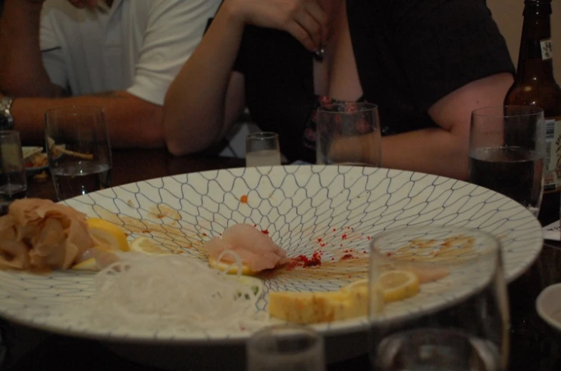 two people sitting at a table with food