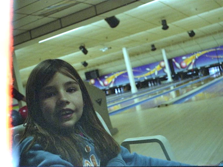 a girl posing for a po next to bowling alley