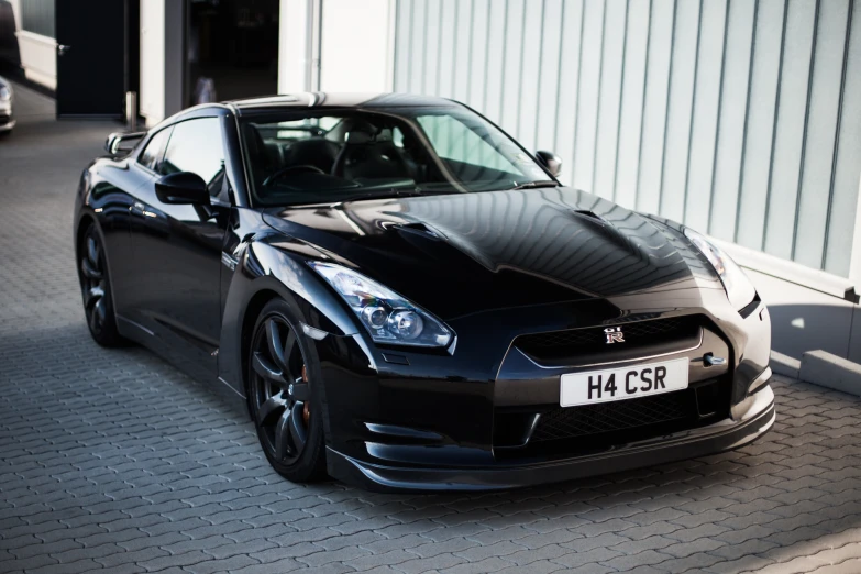 the black sports car is parked in front of a building