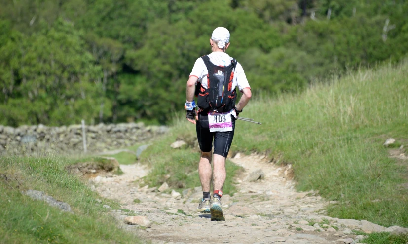 a man is hiking in the grass with an oxygen device