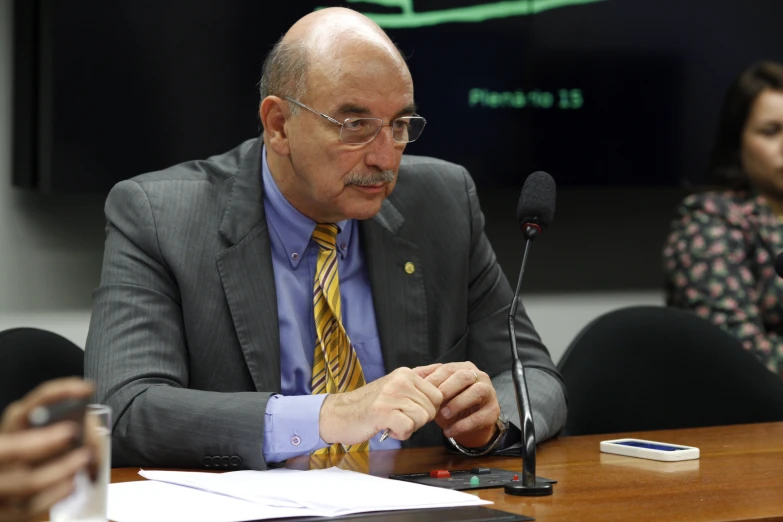 a man with a microphone at a table