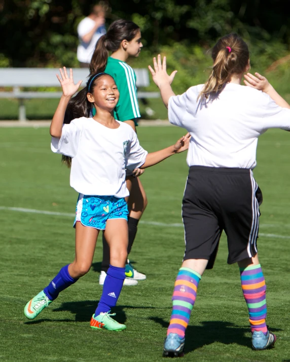 some little girls are playing with a soccer ball