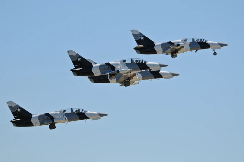 four jet planes flying in formation in the sky