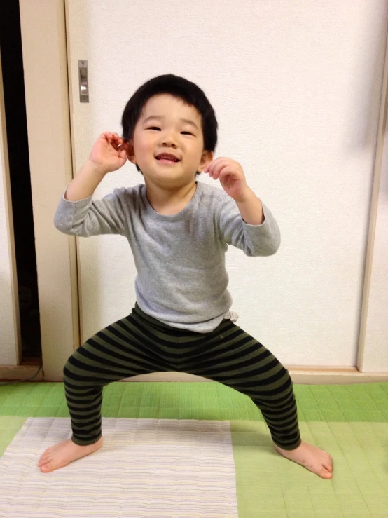 a small child posing with hands up