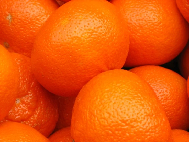 large pile of bright oranges with one is ripe