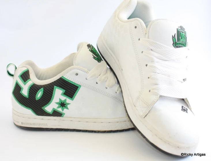 two white and green shoes sitting side by side