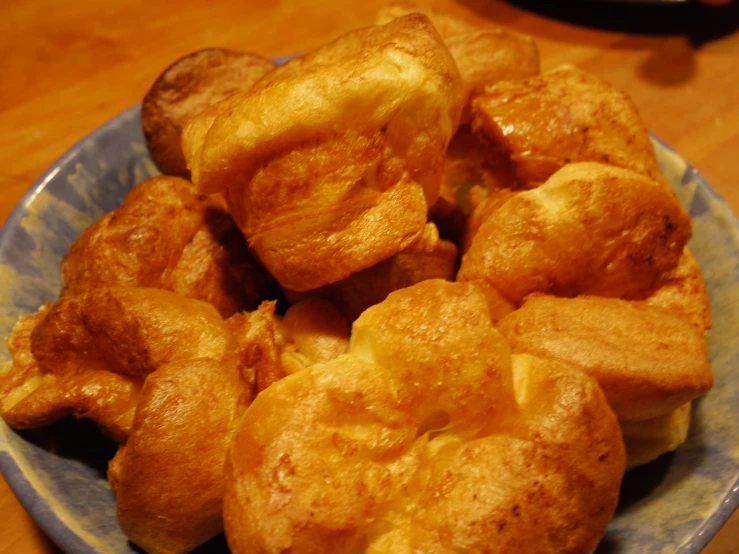 a plate filled with rolls on top of a wooden table