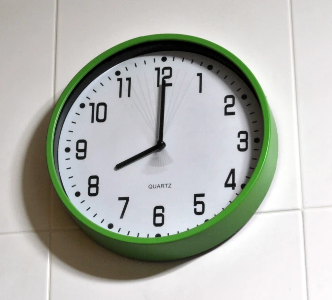 a close up of a wall clock on a tile floor